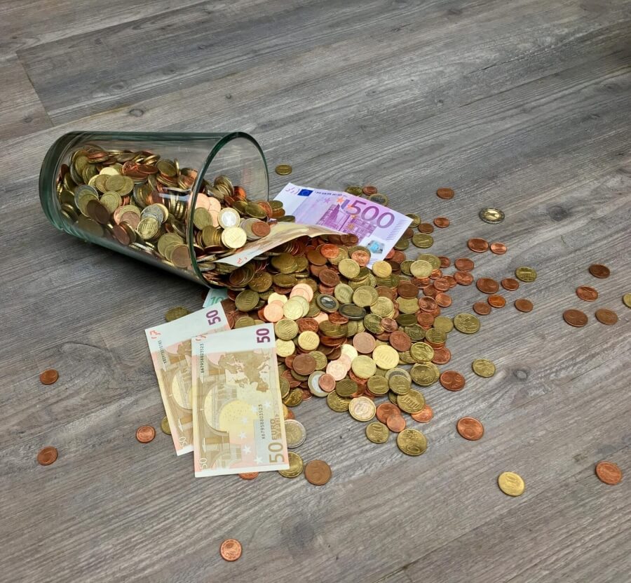 Ein umgestoßenes Glas mit Euros
